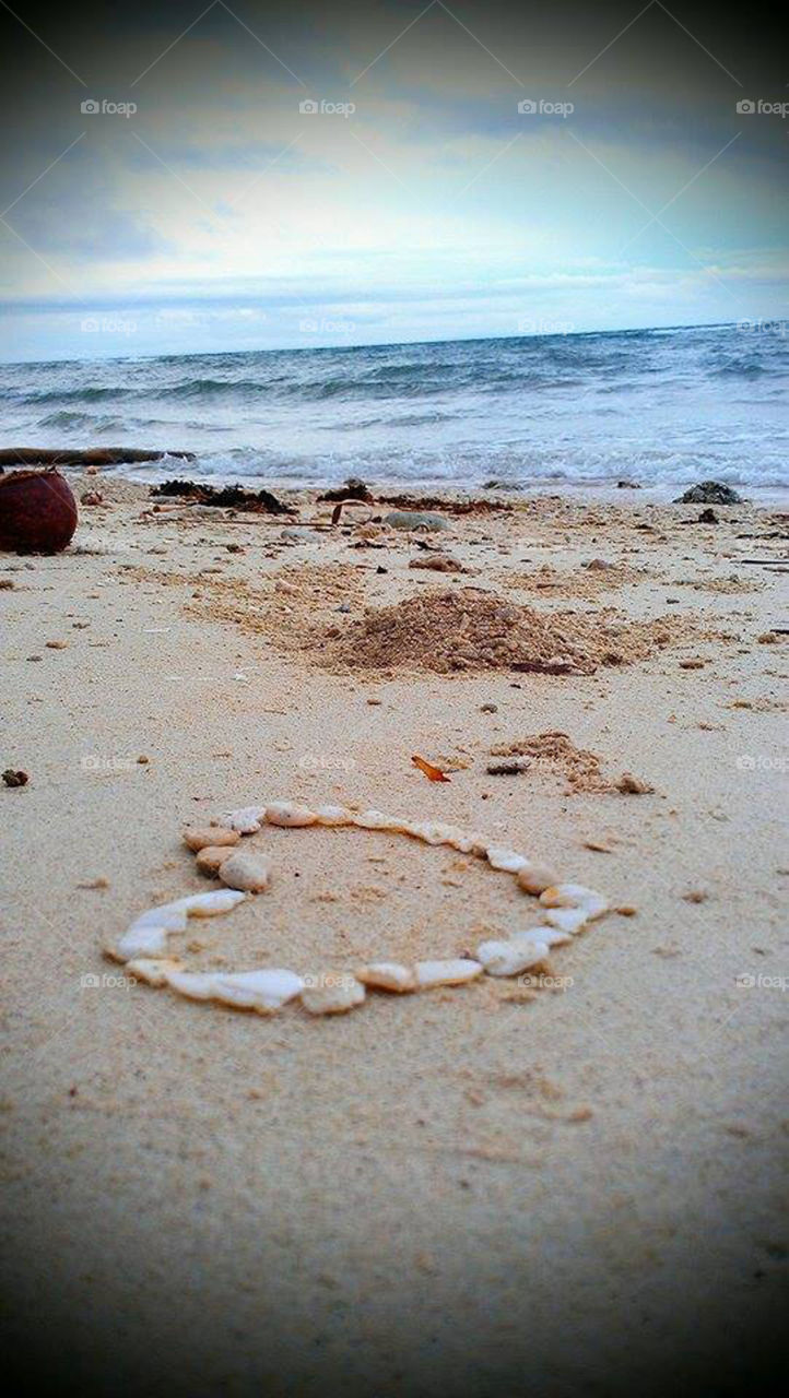 Gathered pebbles and formed a shape of a heart in the seashore. Sign and symbol of love associated with nature.