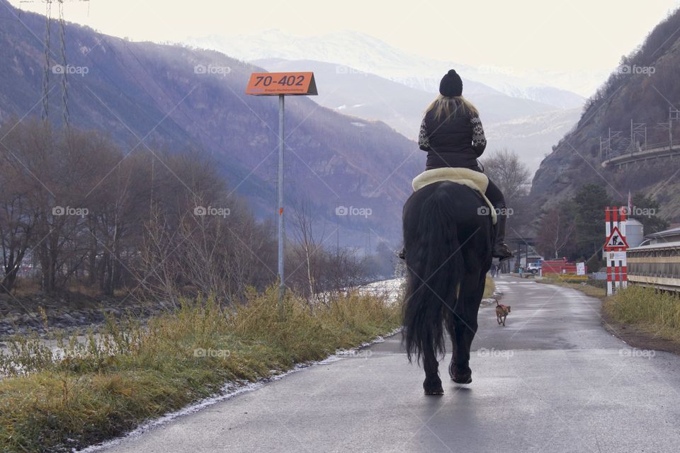 Rear view of woman riding a horse