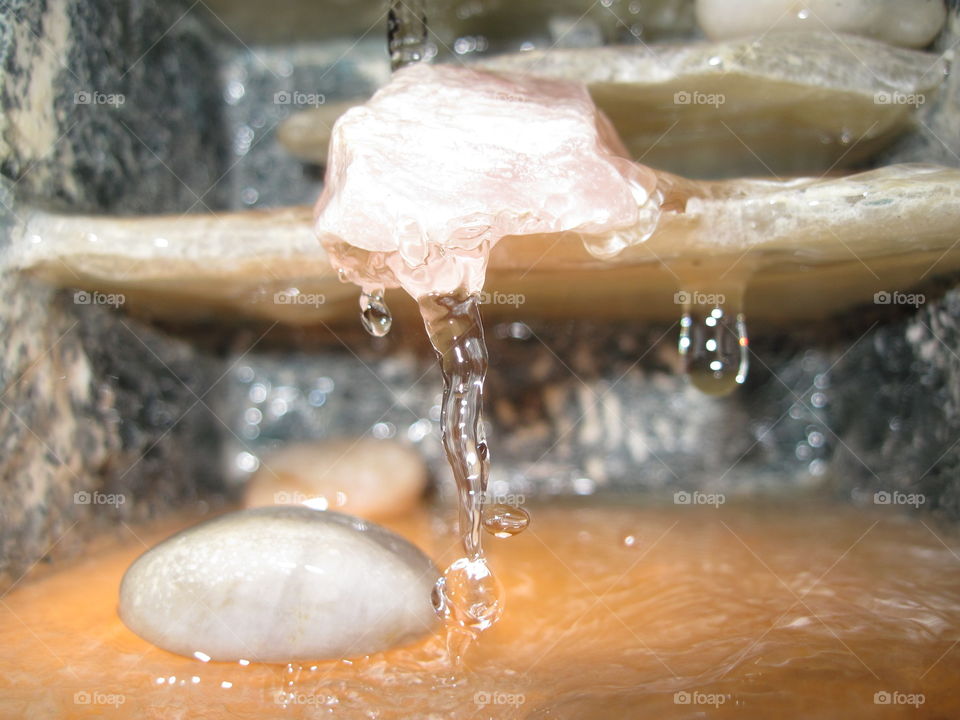 Waterdrops Falling from Pink Rock