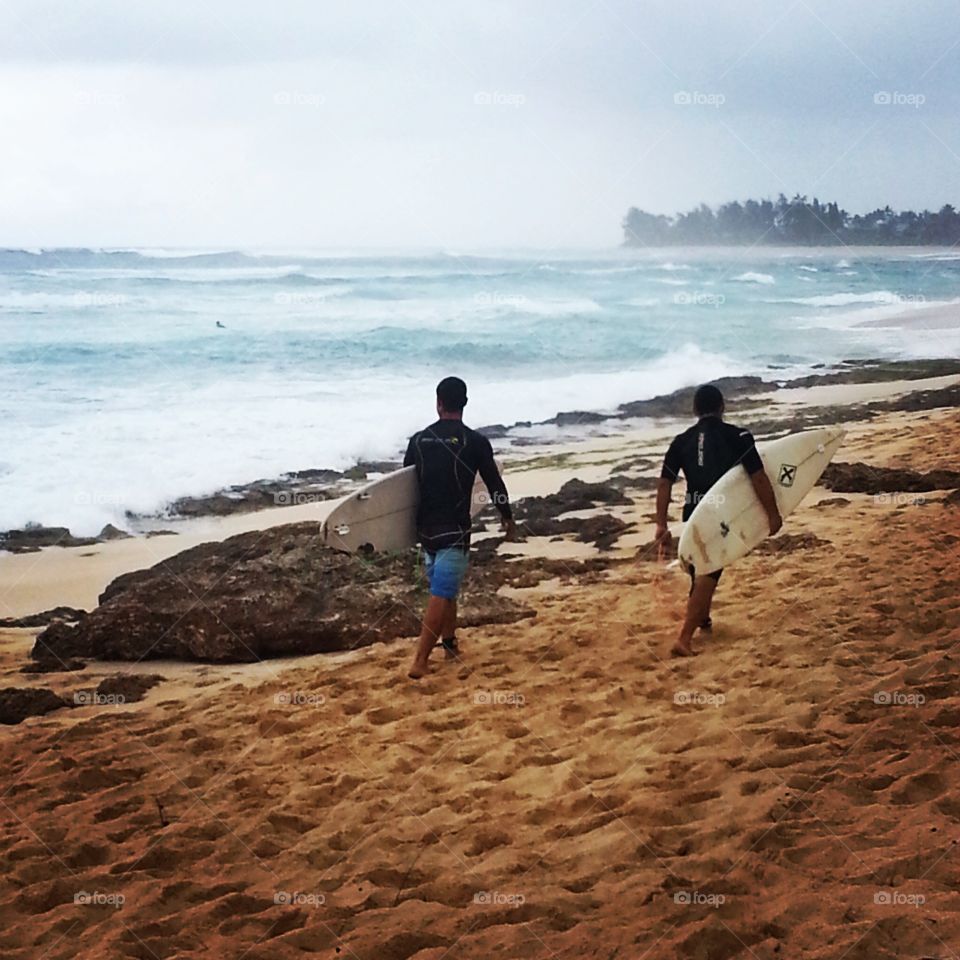 Surfers at Banzai Pipeline at the North Shore, Hawaii
