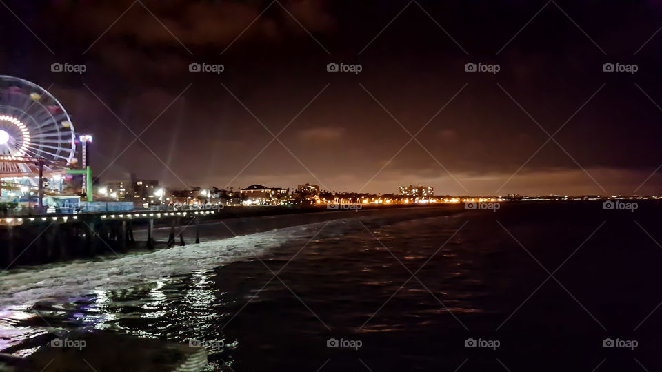 A lovely night view of the Pacific coastline and big city lights off Santa Monica Pier in Los Angeles, California.