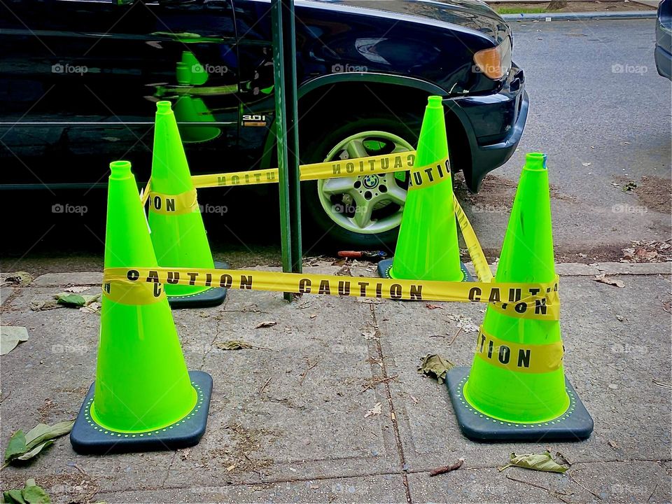 Four neon green plastic cones to serve as markings between which to place yellow barricade tape to designate an area that is prohibited to enter. 2022. Hypnotic Productions