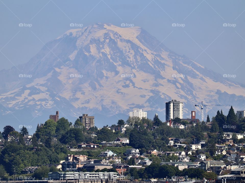 Mount Rainier hugs the bustling, waterfront city of Tacoma Washington on a clear summer day