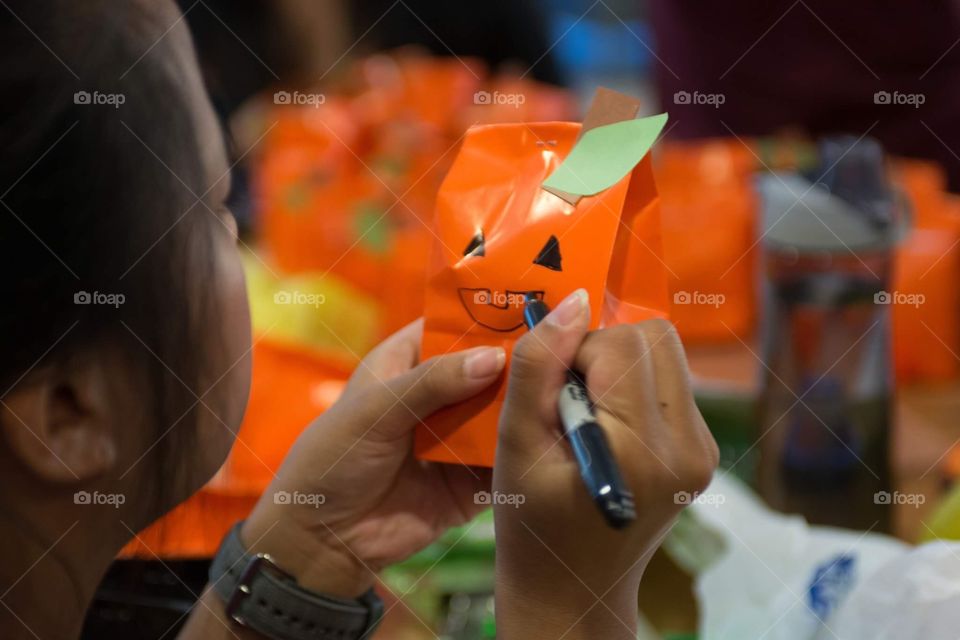 Girl decorating with cute Halloween pumpkin themed bags 