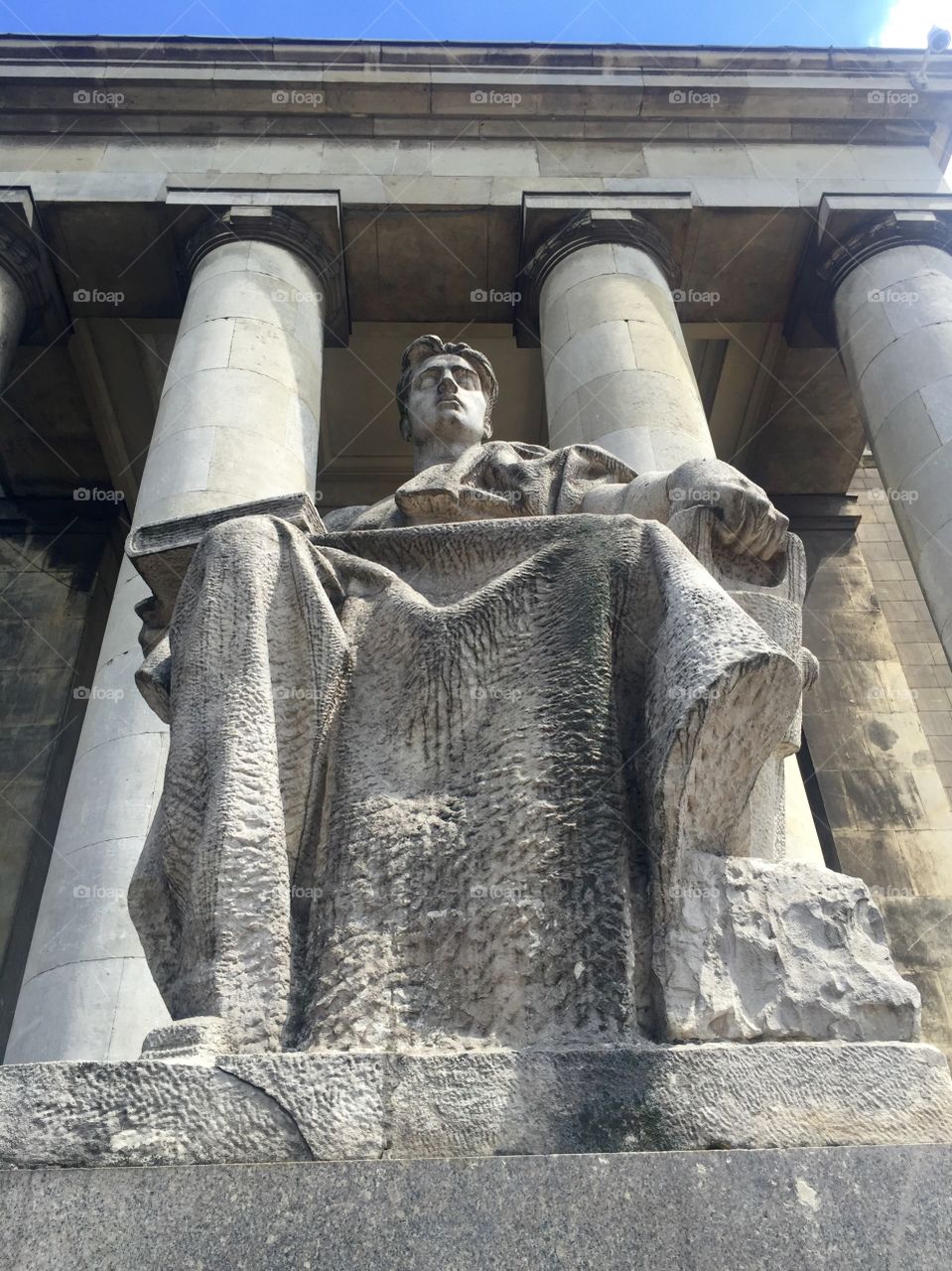 A statue of a young man sitting with a book