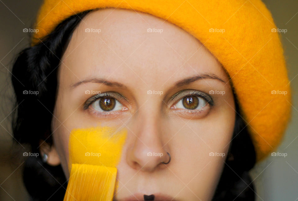 Portrait of woman's face in yellow color, close up