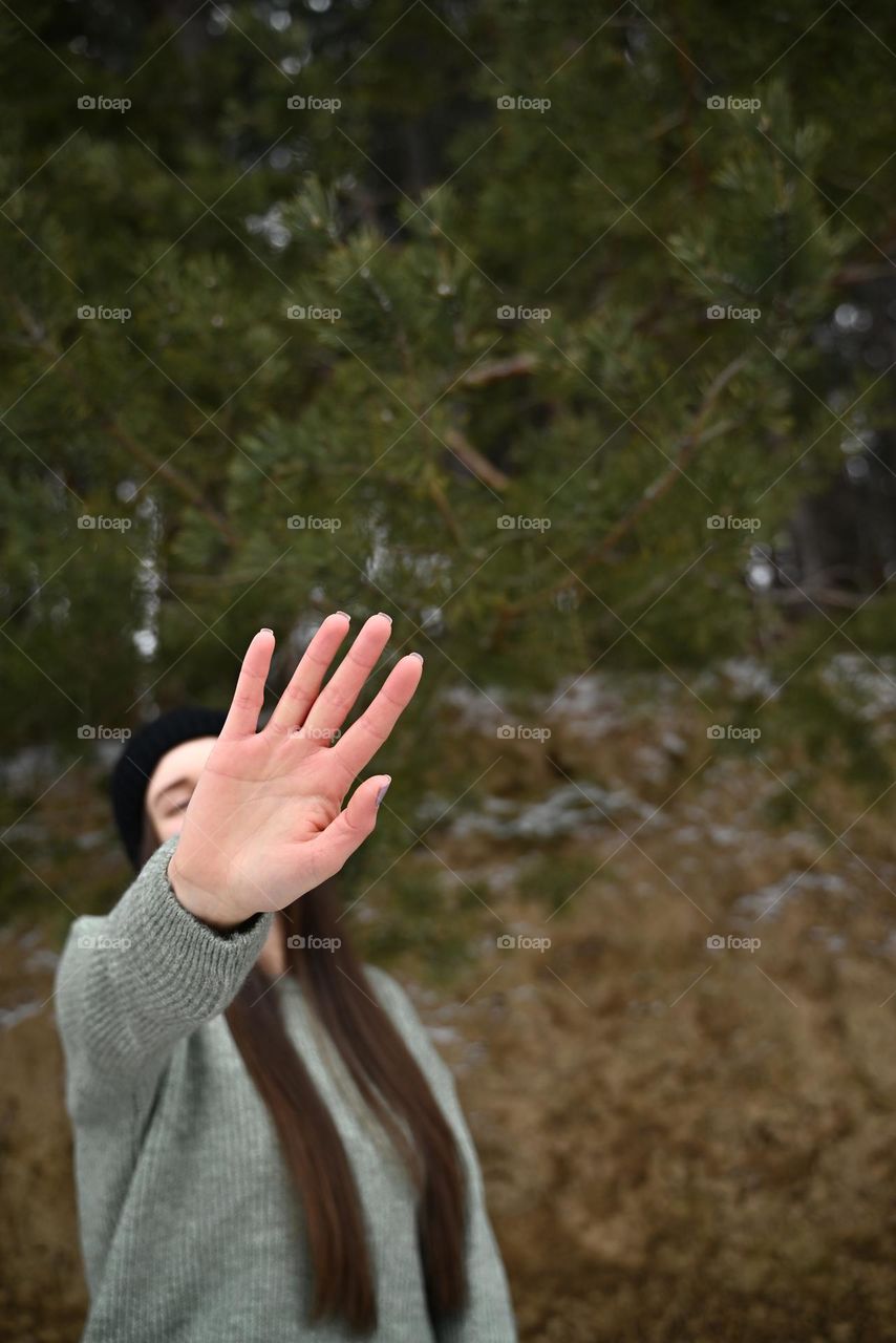 A girl in a cold winter day in a pine forest
