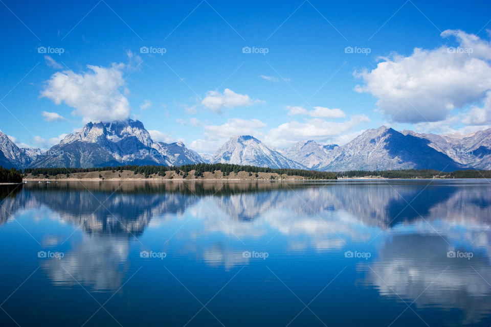 Snowy mountain reflecting on lake