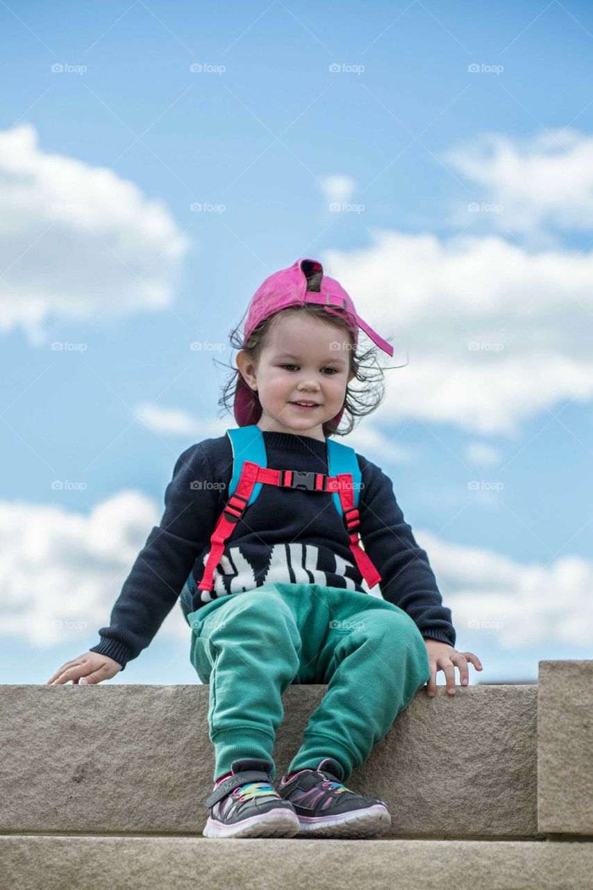 Stylish baby boy sitting on steps