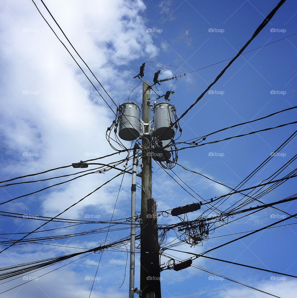 Utility pole with electric and telephone wires stretching in all directions 