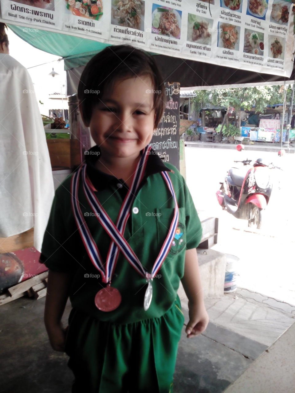 young mixed race Asian boy winner with medals smiling . model Thitiwin Dupont 