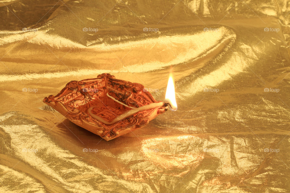 Indian festival Diwali diya oil lamp on golden background