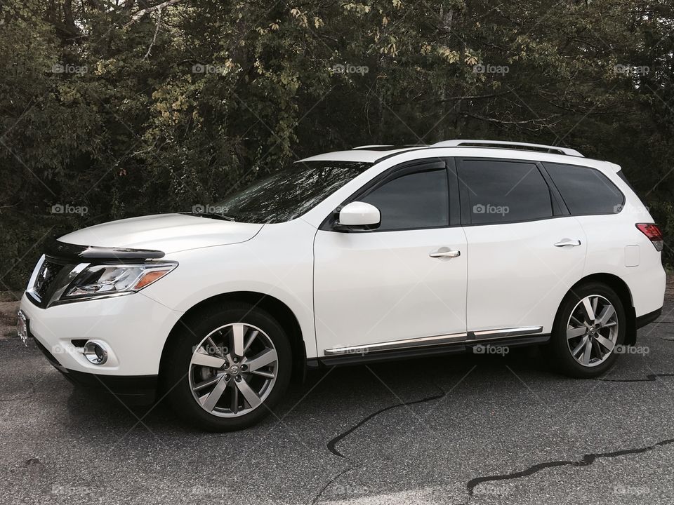White Nissan Pathfinder, bug deflector on front.