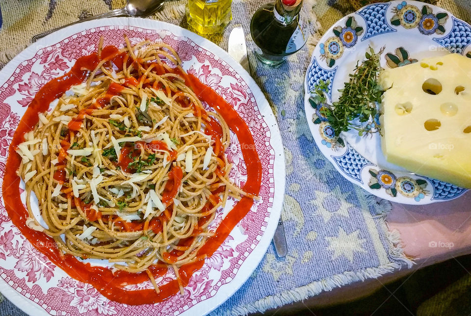 Close-up of Spaghetti with thyme, cheese and tomato sauce