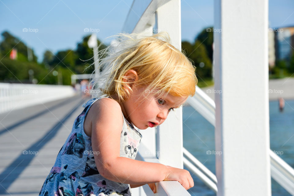 Curious little girl of two years old looking out to sea from Ribban in Malmo Sweden.