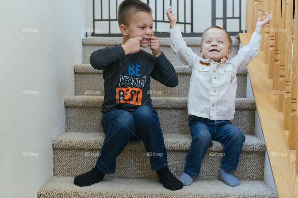 Two happy brothers being silly on the stairs