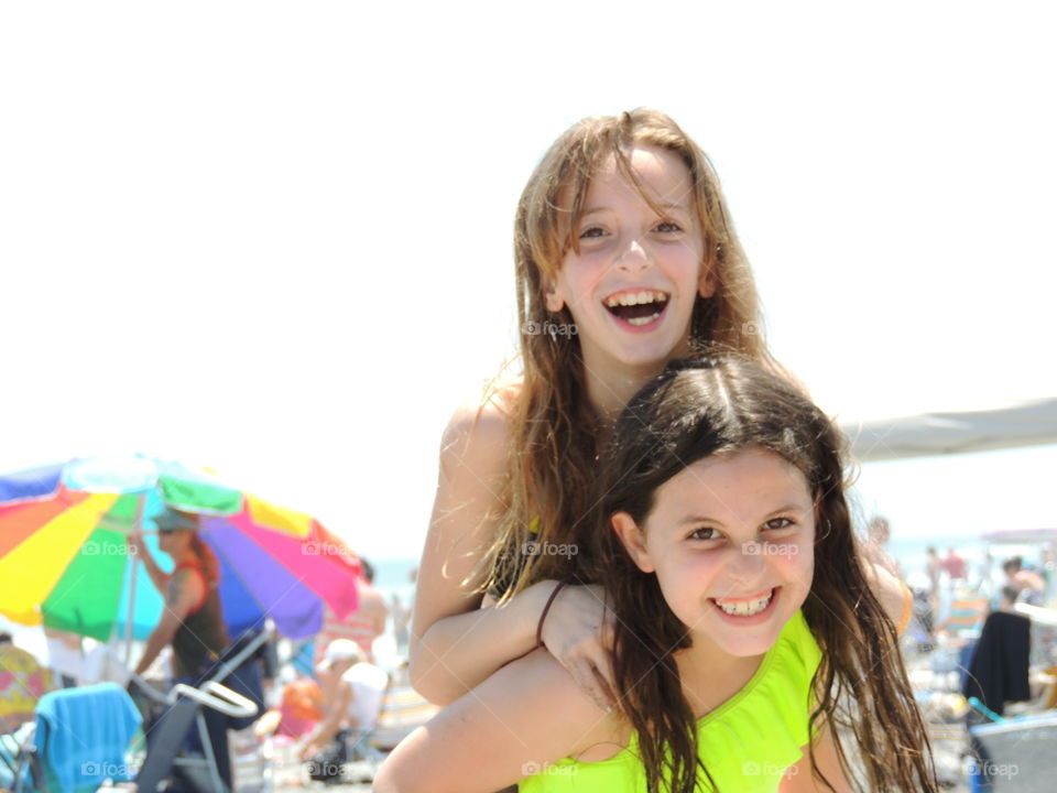 Young girl carrying her sister in piggy back