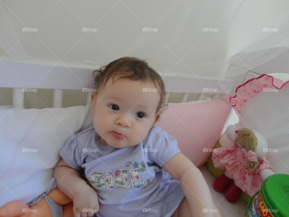 Baby girl sitting in crib