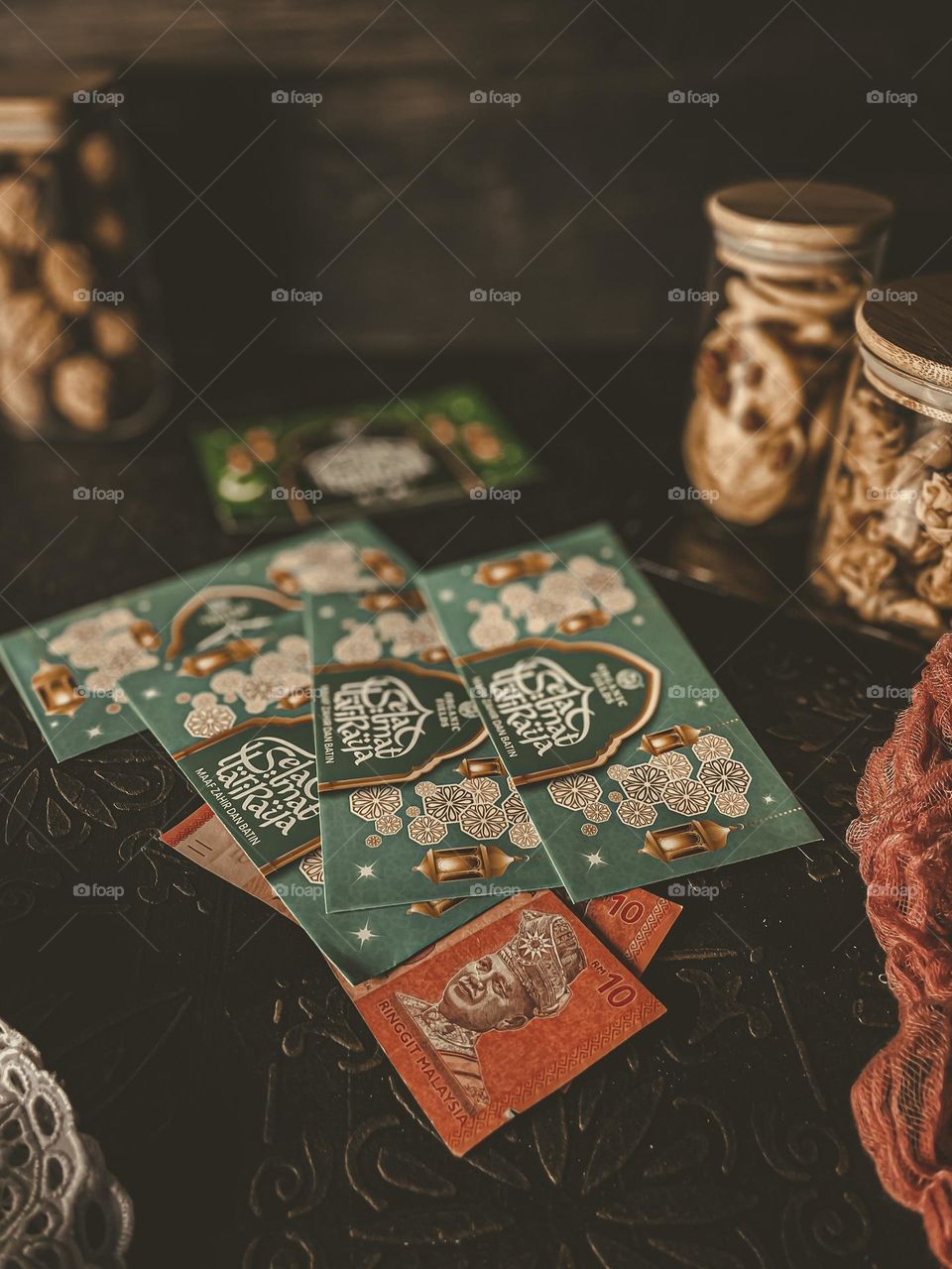 Sampul raya or money gift in an envelope for raya celebration and some biscuits in a jar