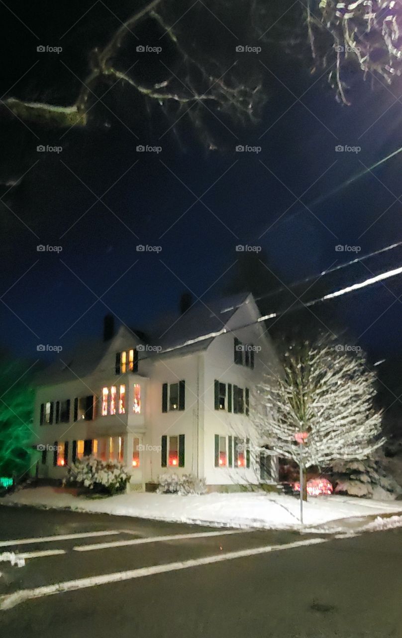 Long Exposure. Home at night with Christmas Lights lit, starting to snow.