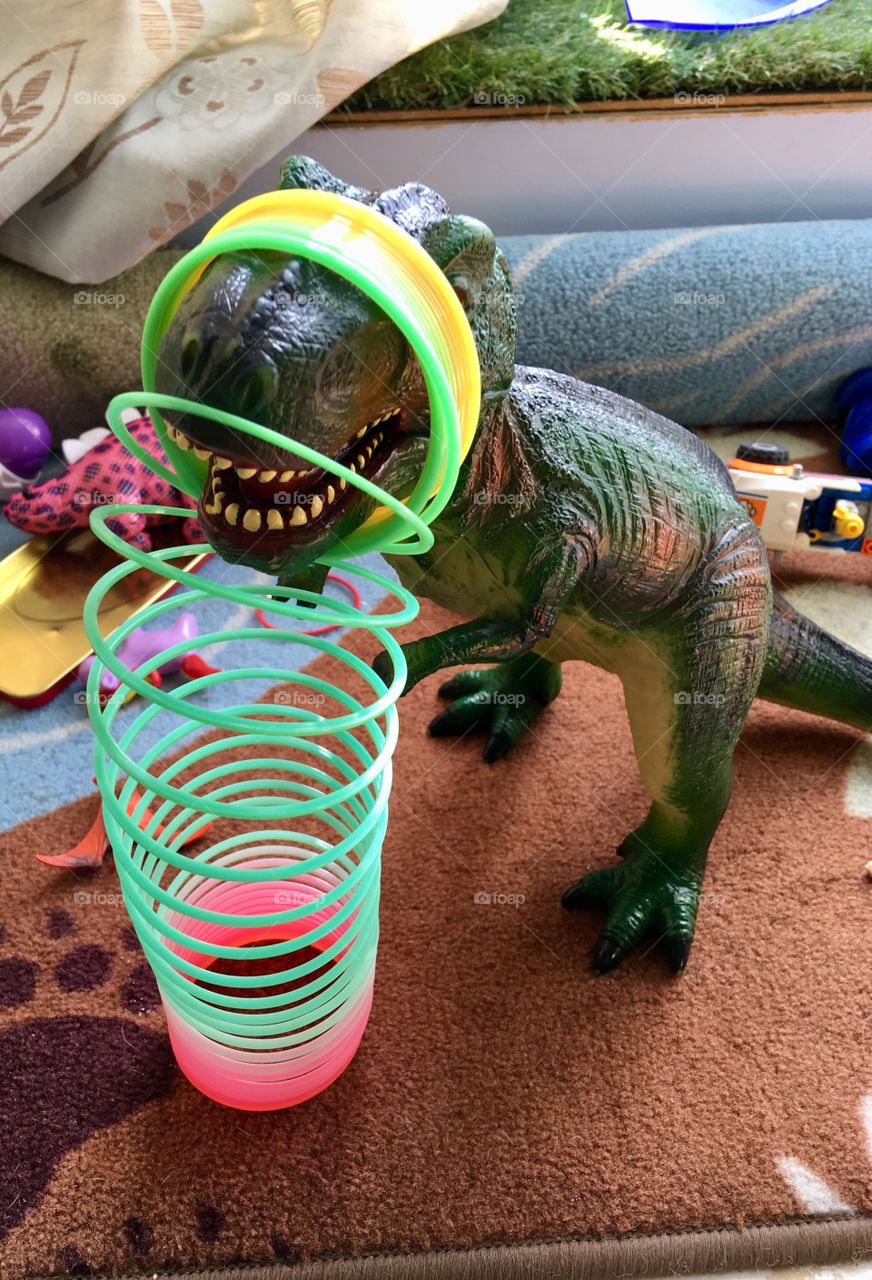 The imagination of a child, the story that evolves from his mind. You see a Tyrannosaur and a Slinky, I see a Tyrannosaur and a force field. The great play of toys, colour and fun. Enjoy