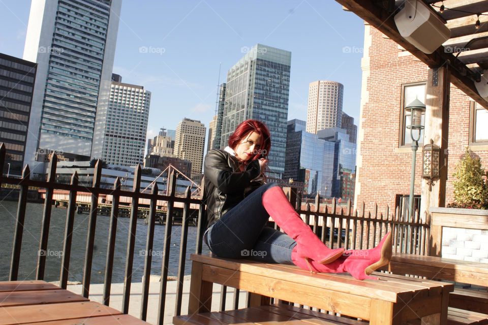 Tables aren’t just for eating, sitting on the table, with the city behind, the city of boston, bean town to be exact, seaport sitting, boots of walking and jackets for warming. 