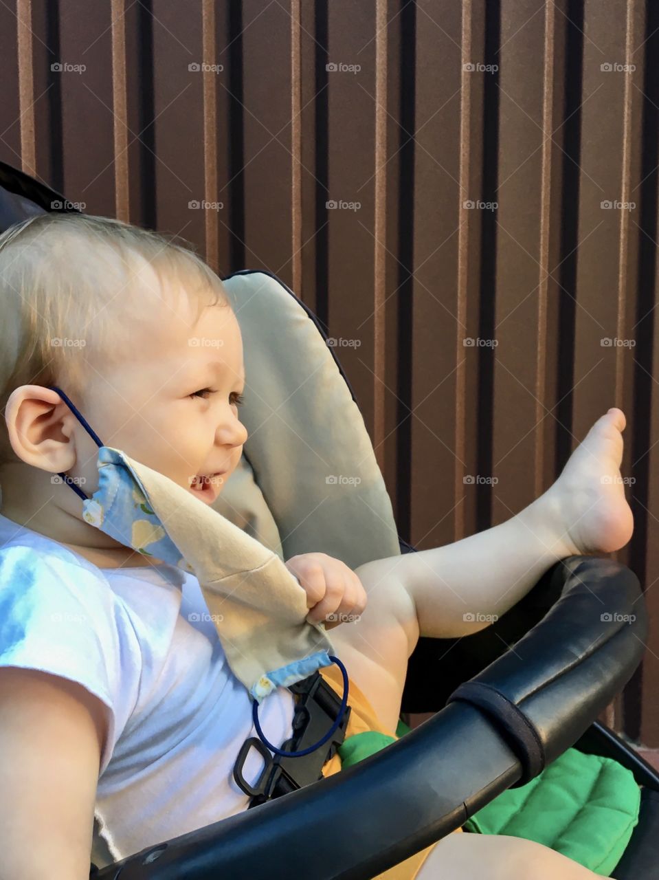 Little boy takes off the face mask and laughs