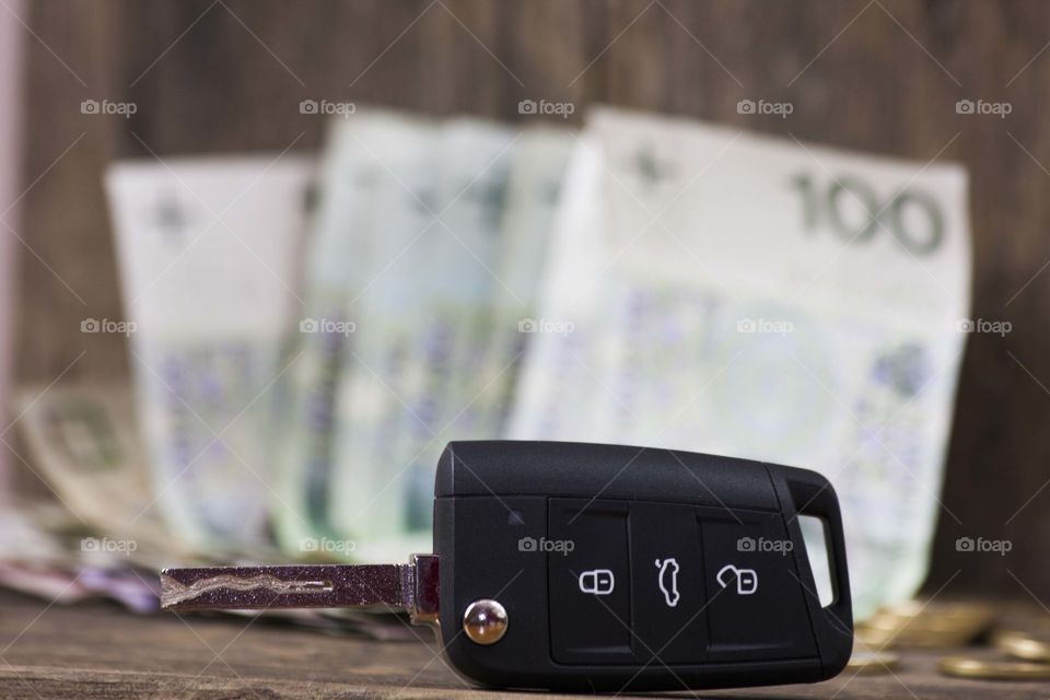 Car's key on money background meening dream of a car
