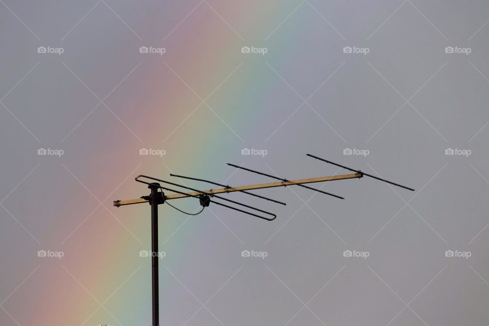 Close-up of a rainbow behind a TV antenna