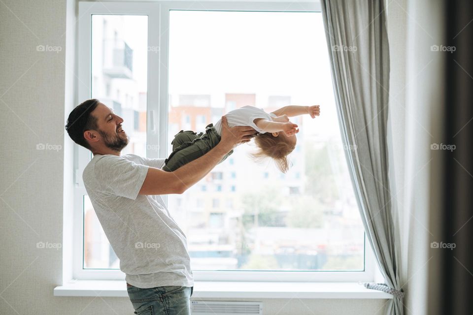 Young happy family with father and daughter having fun in cozy home, father day