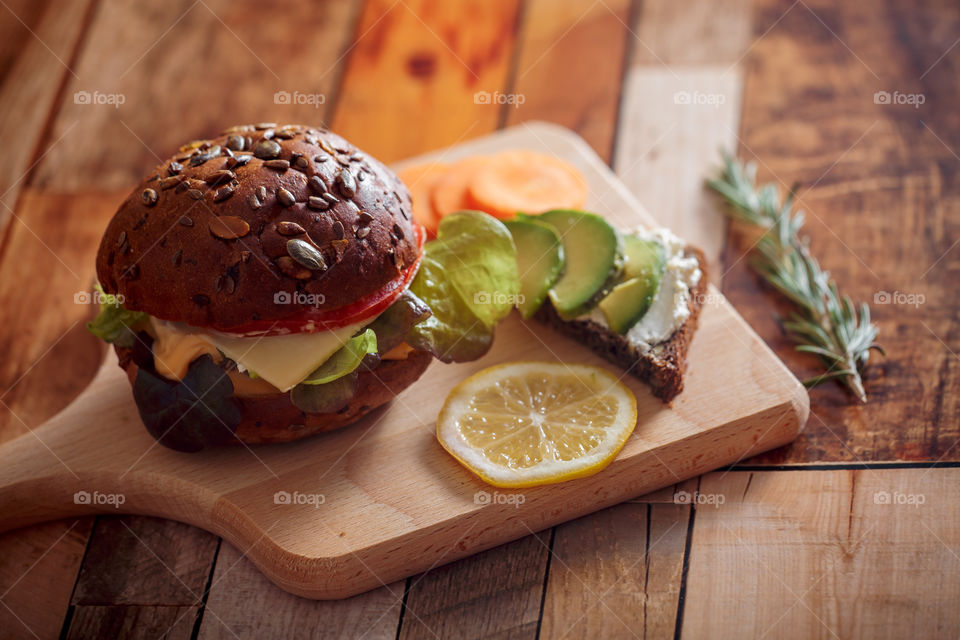 Dark burger with grain bread, cream cheese and avocado