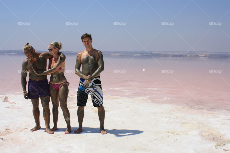 Friends taking mud bath at beach