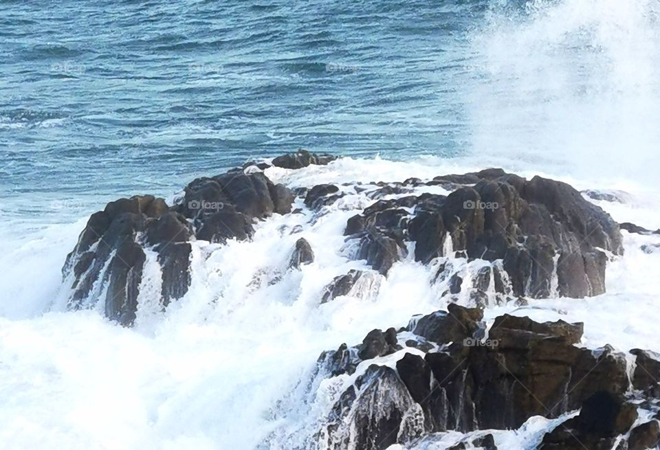 El mar enfadado salta por encima de las rocas. Preciosa naturaleza.