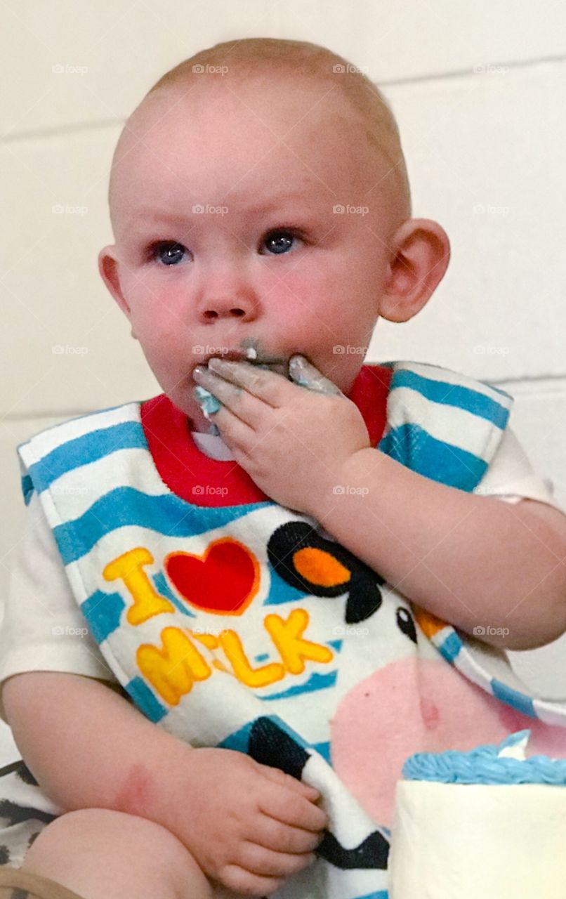 Babies first birthday eating cake off of fingers