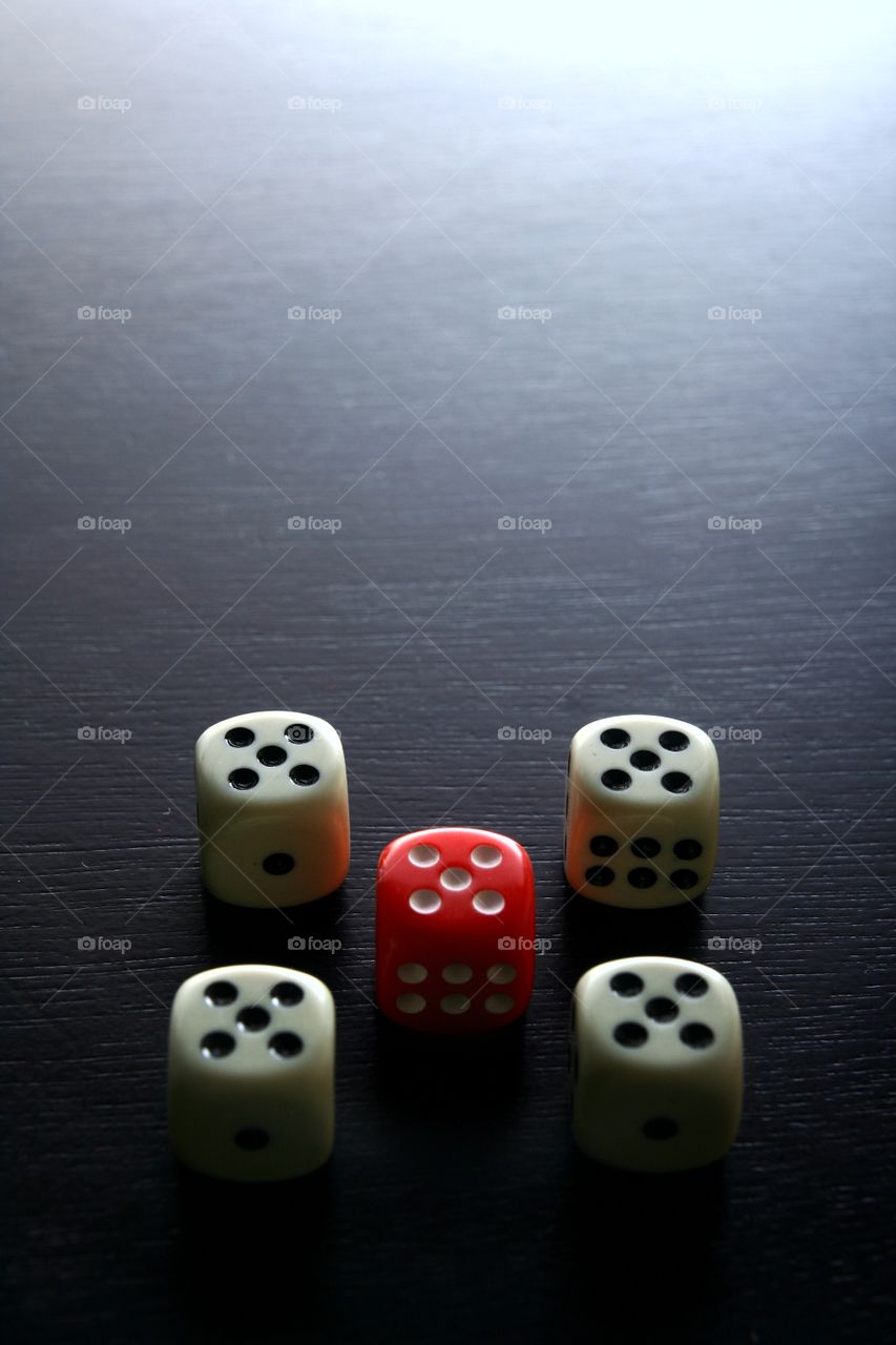 1 red dice among 4 white dice. photo of 1 red dice among 4 white dice