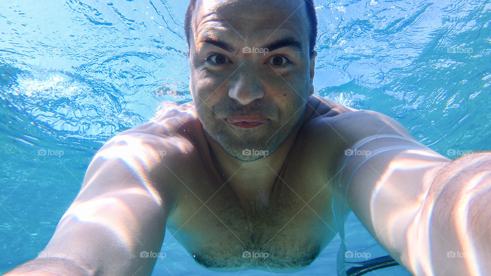 Portrait of shirtless man swimming underwater