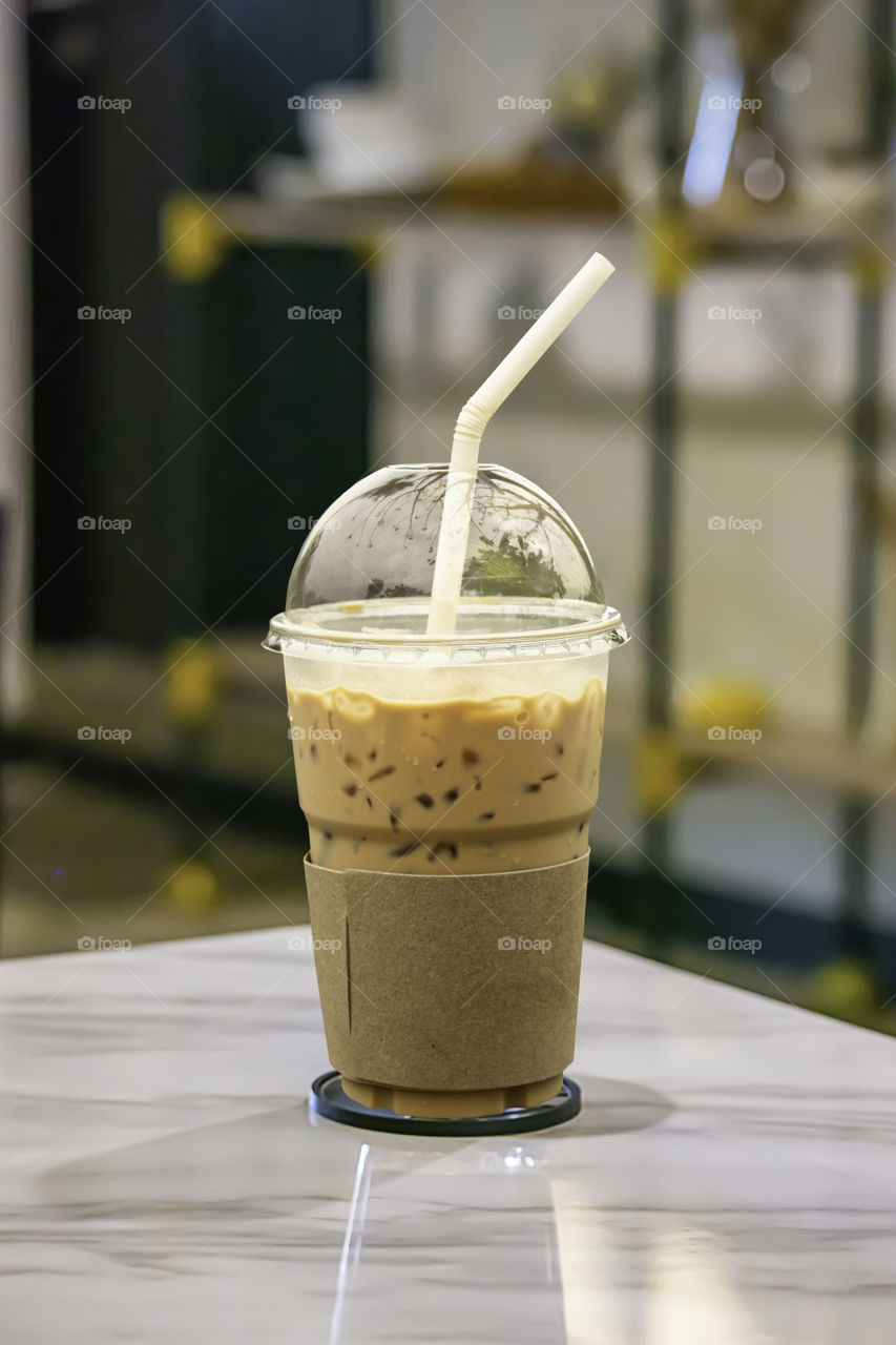 Iced coffee put whipped cream in a glass on the table.