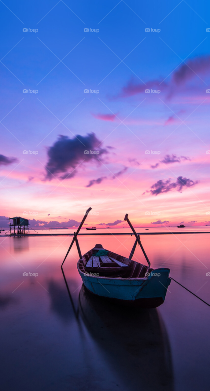 A beautiful sunset picture of a boat in a lake 