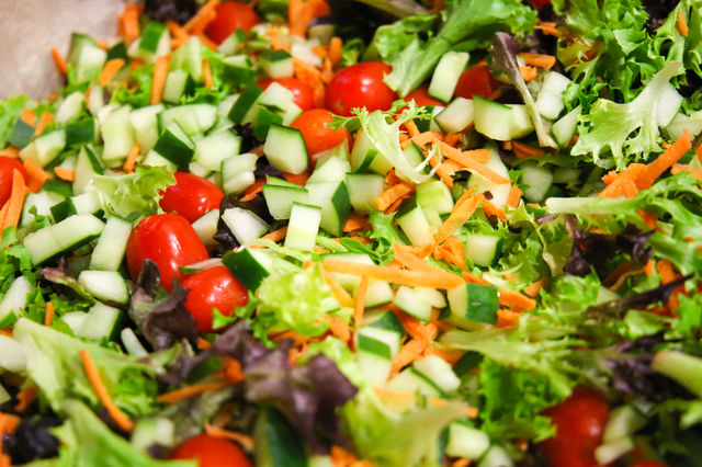 Super healthy organic mix of greens, tomato and cucumbers chopped and made into a colorful salad