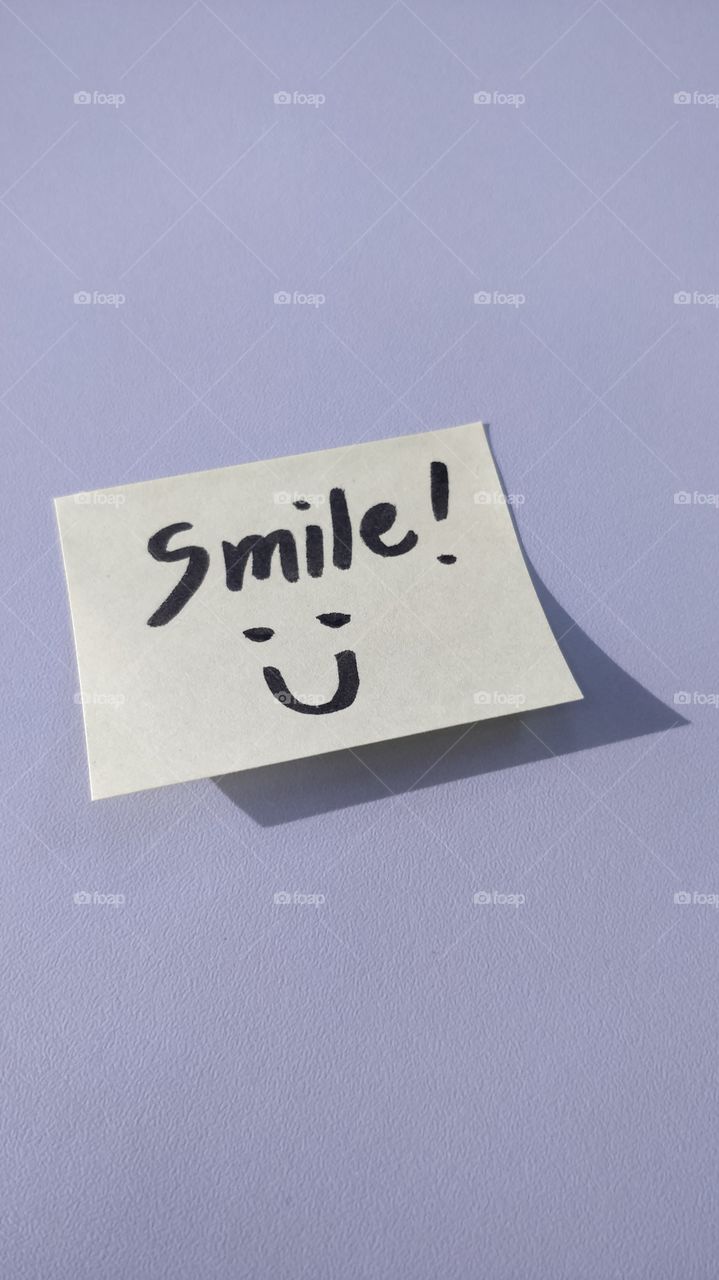 A sticky note with "Smile! Ü" message