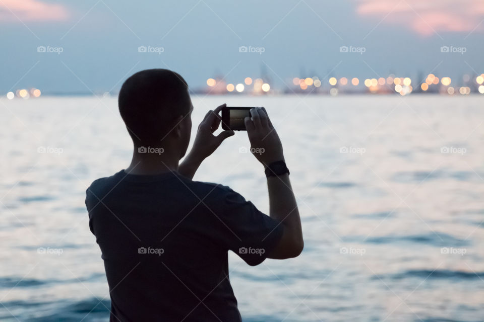 Teenager Photographing A Cityscape With Smartphone
