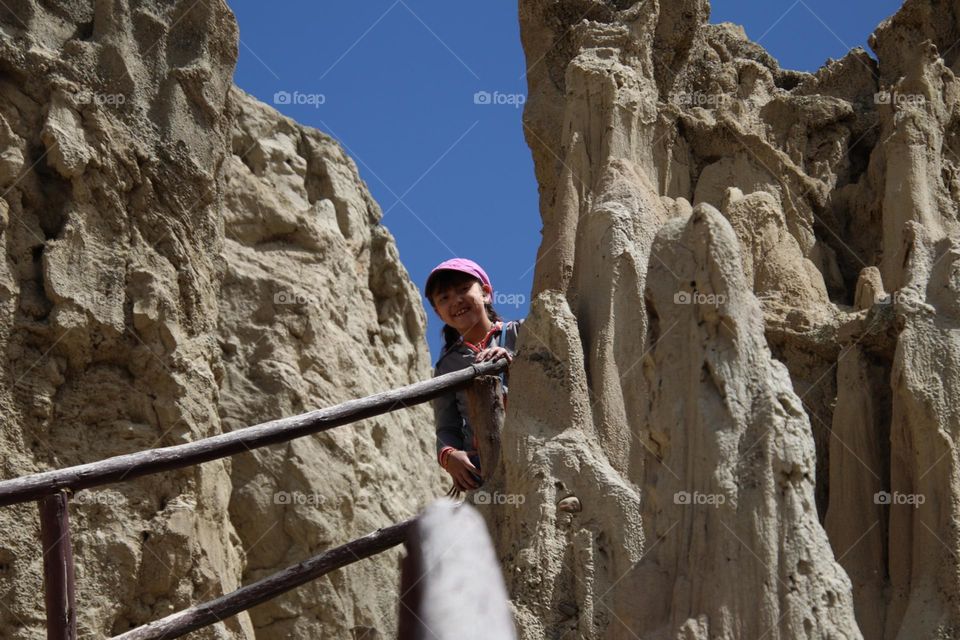 Cute girl is peeking between the rocks