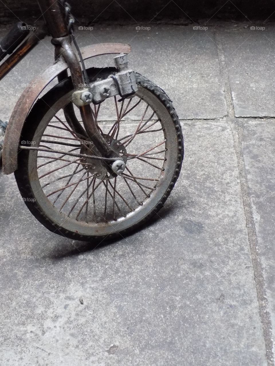 Old, rusty and broken toy bicycle