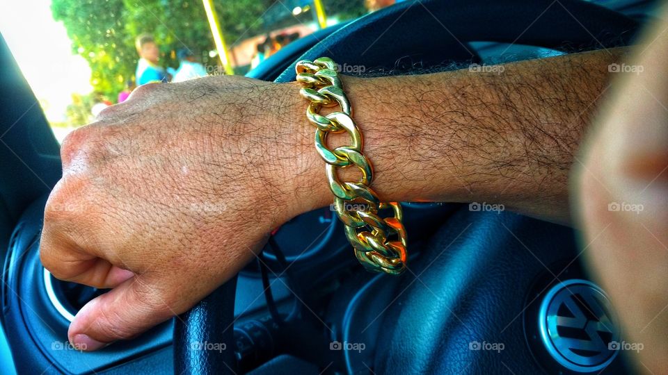 Pulseira de ouro no pulso.