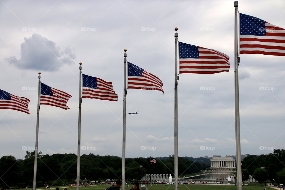 Flags and airplane flying in front of Lincoln Memorial