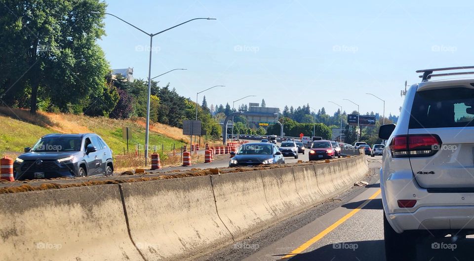 line of cars driving toward the camera in Oregon commuter traffic on a blue sky day