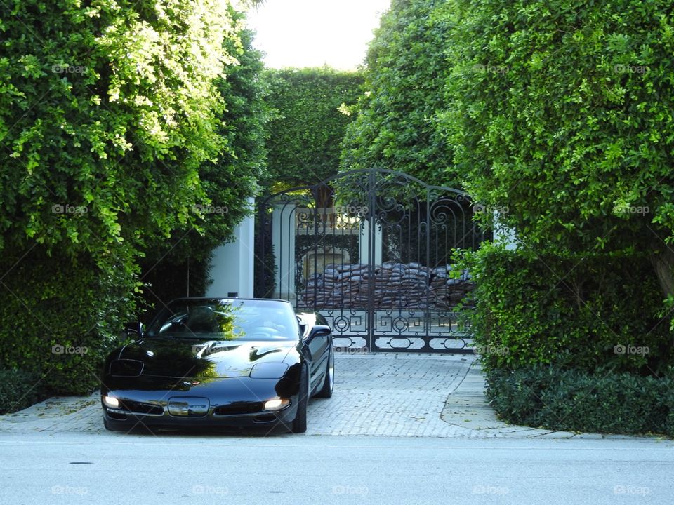 Black convertible Corvette leaving the mansion