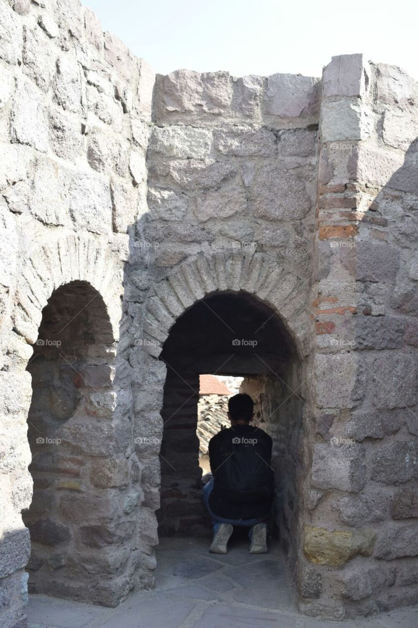 me sneaking a peak through a small window at the top of Ankara castle in Turkey