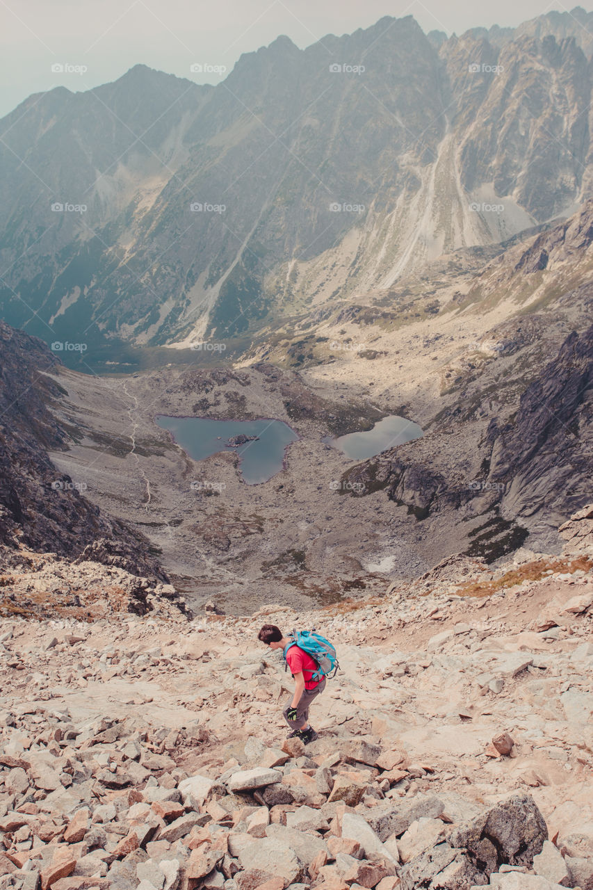 Hike in the Tatra Mountains. Boy walking down the rocky mountain in the Tatras