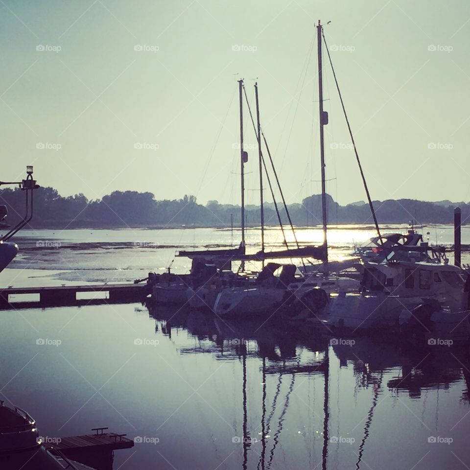 Boats on a still sea hazy reflections